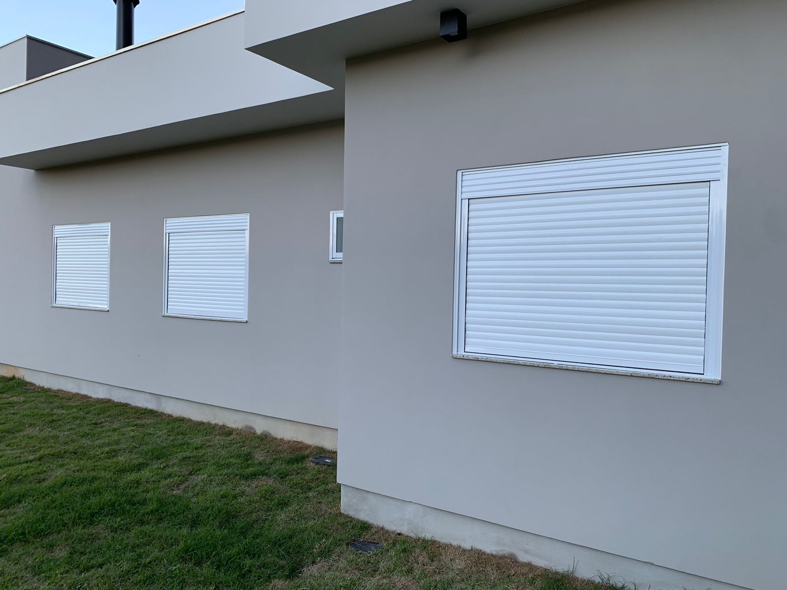 Janelas de alumínio branco com persiana integrada em fachada