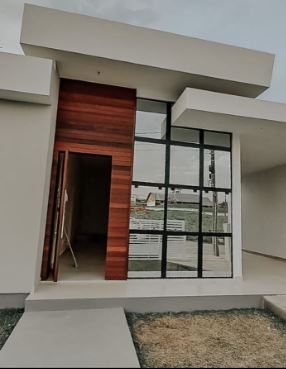 Porta de madeira ao lado de esquadria de alumínio preta