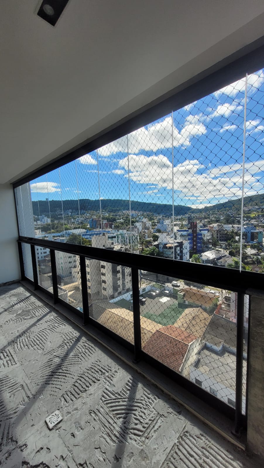 Sacada envidraçada com vista para a cidade